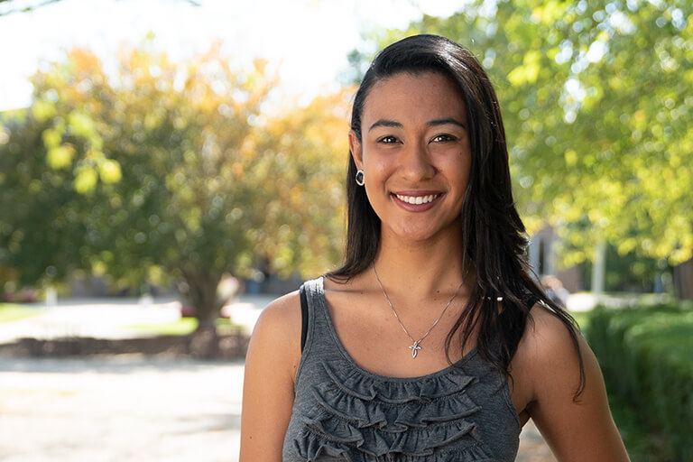 a woman wearing a tank top standing outside